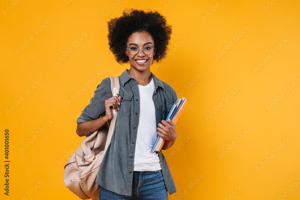 Joyful african american girl in eyeglasses posing with exercise books Joyful african american girl in eyeglasses posing with exercise books