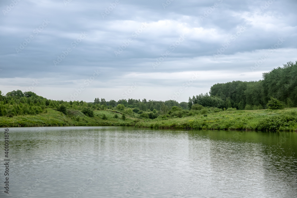 Landscape with lake, forest and rain clouds.