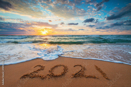 Fototapeta Naklejka Na Ścianę i Meble -  Happy New Year 2021 concept, lettering on the beach. Written text on the sea beach at sunrise.
