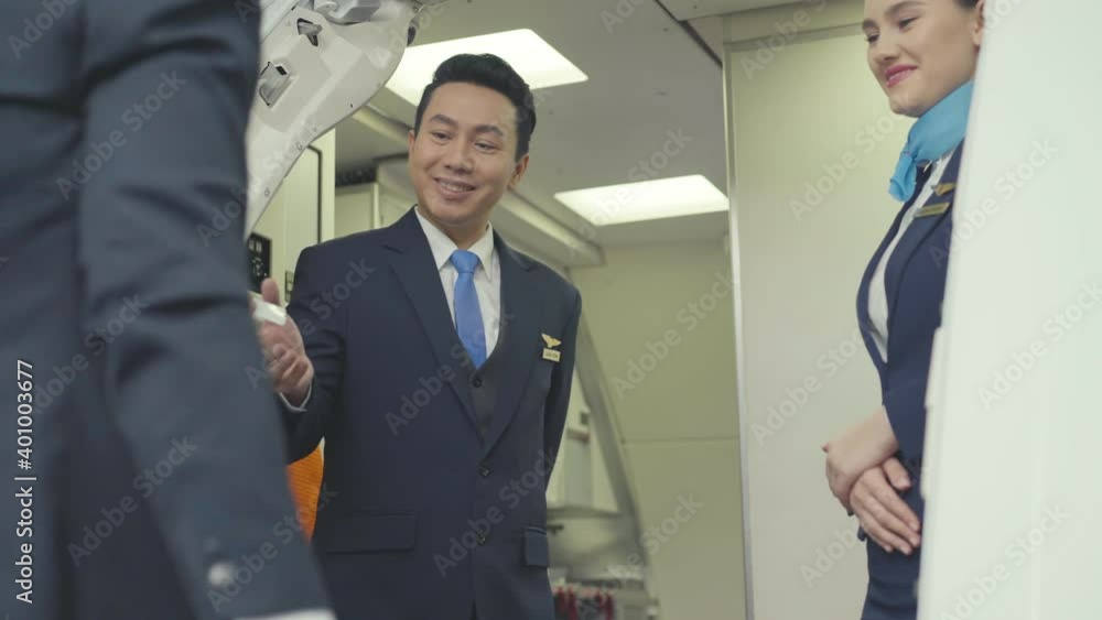 Happy diversity Asian steward man and female air hostess standing at entrance gate smiling and welcome passengers to the airplane. working abroad or travel concept for airline business. Happy diversity Asian steward man and female air hostess standing at entrance gate smiling and welcome passengers to the airplane. working abroad or travel concept for airline business.