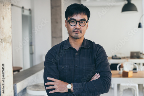 asian man portrait young male wear eye glasses smiling cheerful look thinking position happy with perfect clean skin posing on office background.fashion people life style concept