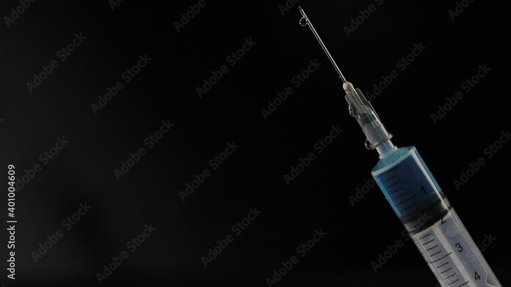 Seringa de vacina com gota escorrendo na agulha