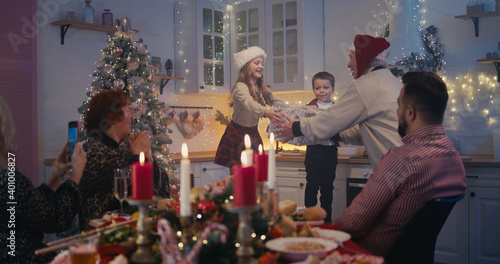 Adorable children performing poems on Christmas dinner with family