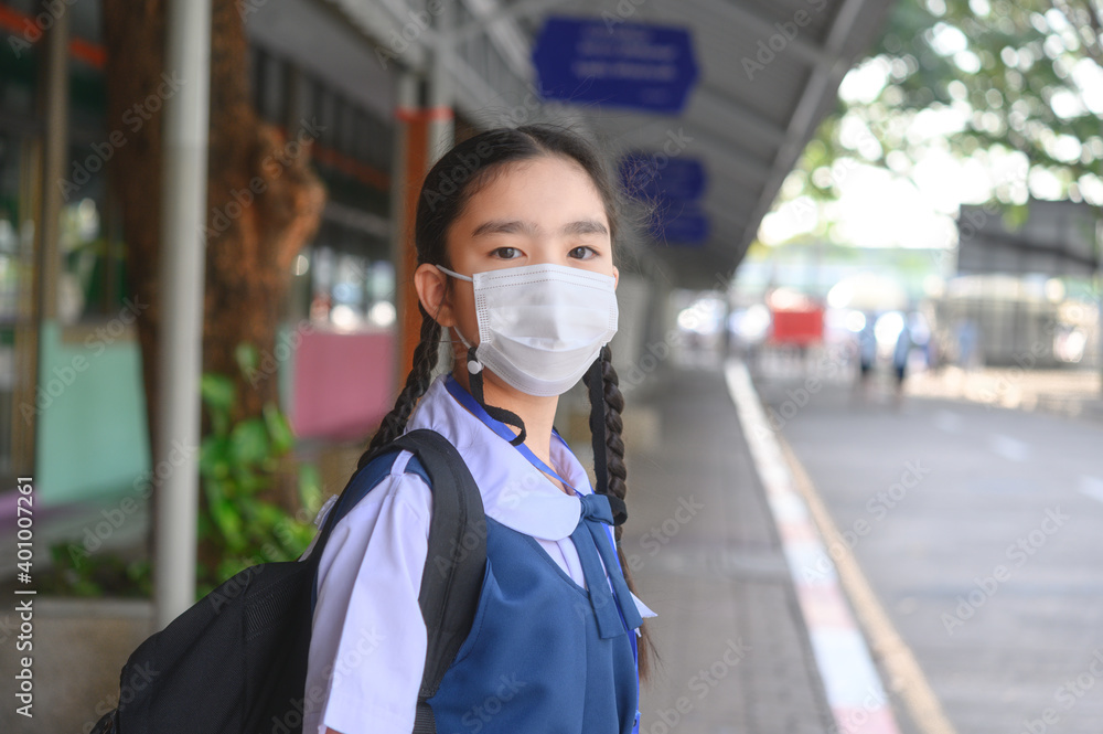 Back to school. asian child girl wearing face mask with backpack going to school .Covid-19 coronavirus pandemic.New normal lifestyle.Education concept..
