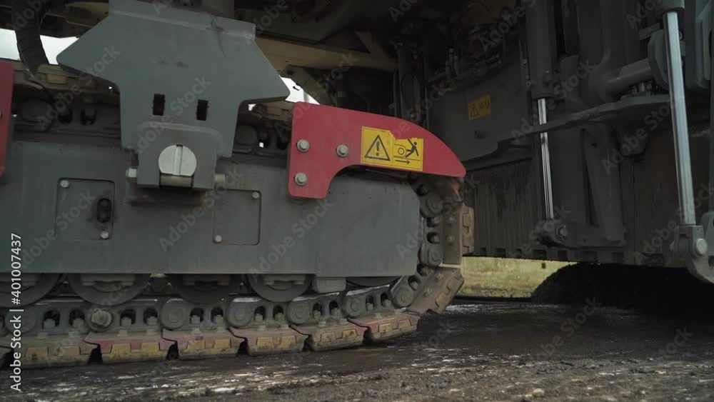 tracked road milling machine in motion on the road. closeup tracked road milling machine in motion on the road. closeup