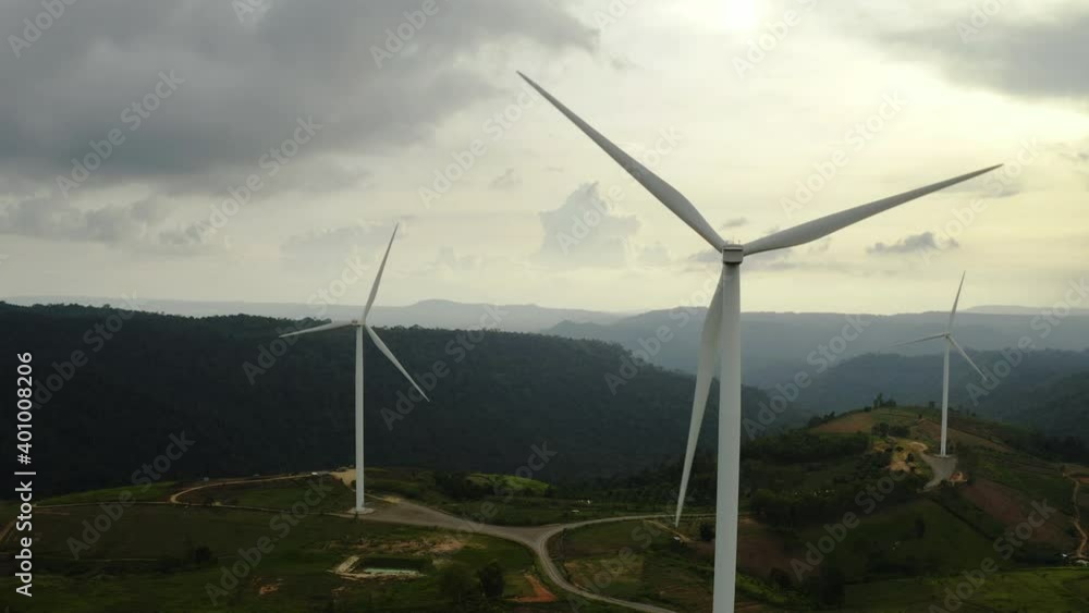 Aerial view, windmills rotating by the force of the wind and generating clean renewable energy for sustainable development in a green ecologic way on cloudy sky at dusk. The look up shot by drone Aerial view, windmills rotating by the force of the wind and generating clean renewable energy for sustainable development in a green ecologic way on cloudy sky at dusk. The look up shot by drone
