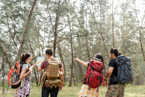 A group of four backpackers is planning a walk in the forest.