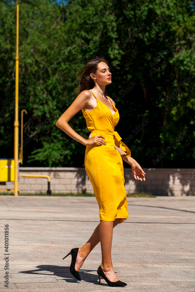 Young brunette woman in yellow dress Young brunette woman in yellow dress