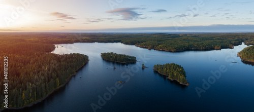 Aerial view of of small islands on a blue lake Haukkajarvi in Helvetinjarvi National park. Blue lake  islands and green forests from above on a summer evening. 
