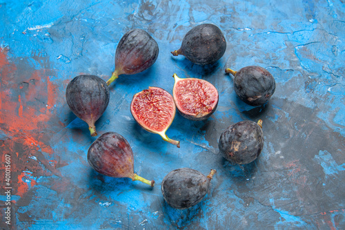 Horizontal view of full fresh black mission figs and split ones on blue background photo