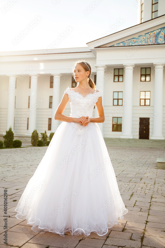 Fototapeta premium Portrait of a young woman in a white ball gown