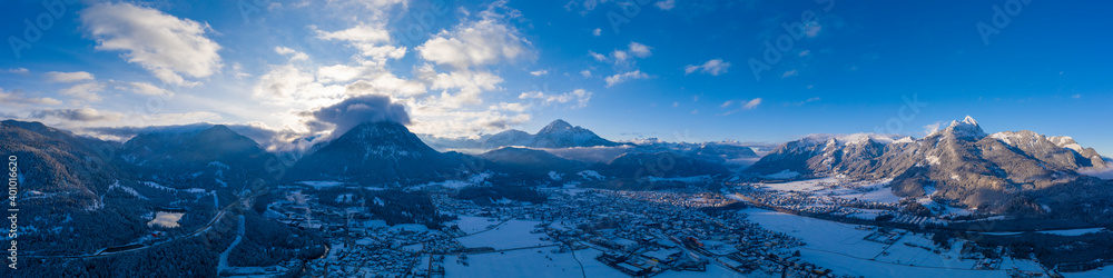 see a large panorama of the reutte basin at sunrise on a winter day