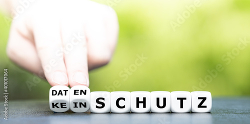 Hand turns dice and changes the German expression "kein Schutz" (no protection) to "Datenschutz" (data privacy).