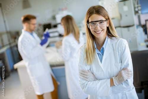 Obraz na plátně Female scientist in white lab coat standing in the biomedical lab