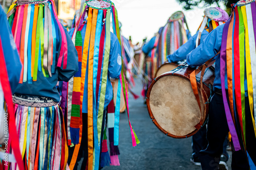 Fitas coloridas e pessoas tocando tambores na Congada, manifestação cultural e religiosa afro-brasileira