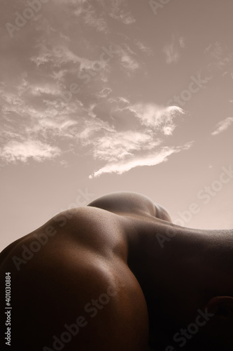 Mountain. Detailed texture of human skin. Close up of young african-american male body surface like landscape with the sky on background. Skincare, bodycare, healthcare, inspiration, fantasy artwork. © master1305