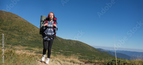 woman traveler with backpack, mountaineering trip, mountain lifestyle concept on summer expedition background. photo