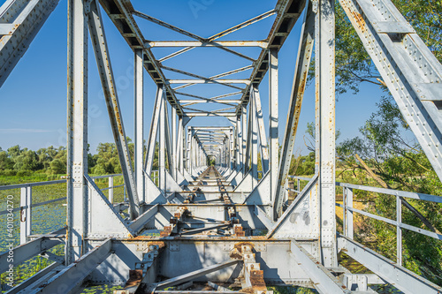Rusty, broken metal railroad bridge called Most Europejski. Construction more than 100 years old and is connecting Poland and Germany over Oder river