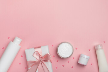 Cosmetic products, gift box and festive decor on pastel pink background. Concept of sale, gifts on Valentines day or mother day. Top view, flat lay, copy space