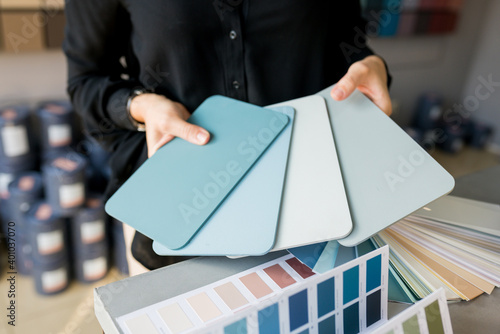 Slika na platnu Close up of Young woman interior designer choosing color swatch for wall