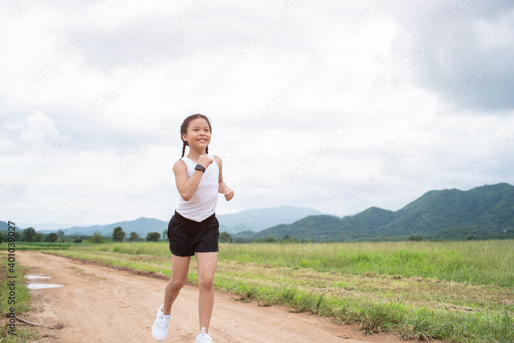 Happy Funny little asian girl fitness woman running at morning tropical forest trail. Athletic young child running in the nature. Healthy lifestyle. Happy Funny little asian girl fitness woman running at morning tropical forest trail. Athletic young child running in the nature. Healthy lifestyle.