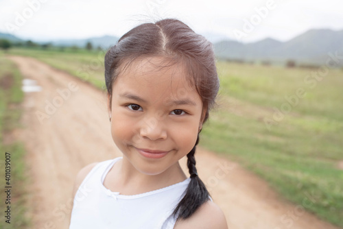 Beautiful asian little girl on the meadow in summer day. Happy little girl on a background of nature. Happy childhood concept.