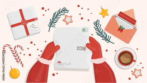 at the table with New Year's and Christmas letters Santa Claus reads letters with requests for a gift