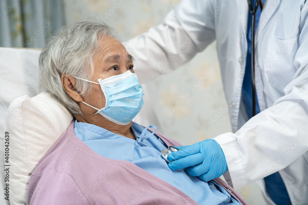 Doctor using stethoscope to checking Asian senior or elderly old lady woman patient wearing a face mask in hospital for protect infection Covid-19 Coronavirus. Doctor using stethoscope to checking Asian senior or elderly old lady woman patient wearing a face mask in hospital for protect infection Covid-19 Coronavirus.