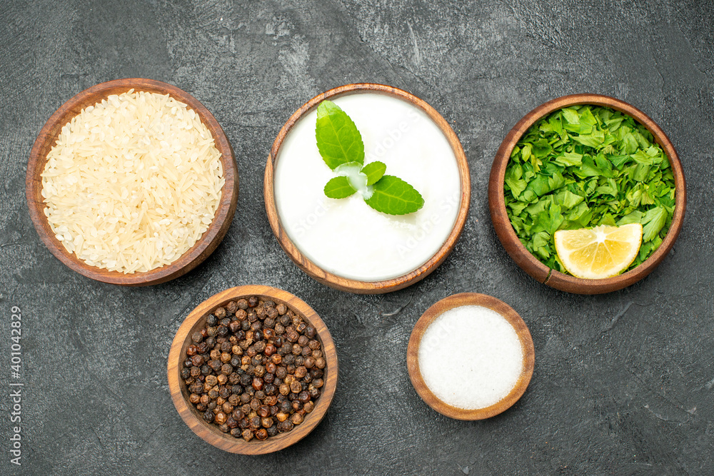 top view wooden bowls with rice natural yogurt parsley black pepper salt on dark background top view wooden bowls with rice natural yogurt parsley black pepper salt on dark background