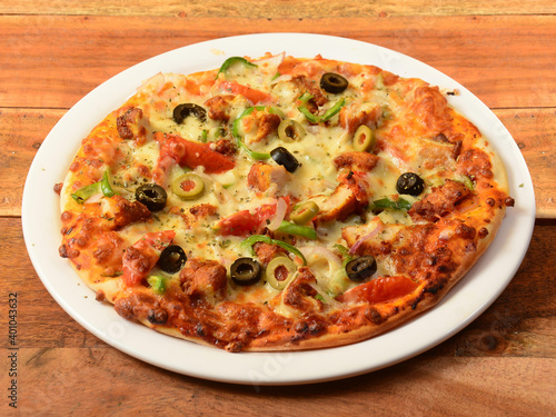 Chicken Pizza isolated over a rustic wooden background, selective focus