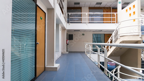 Interior de edificio con escaleras blancas y puertas de madera