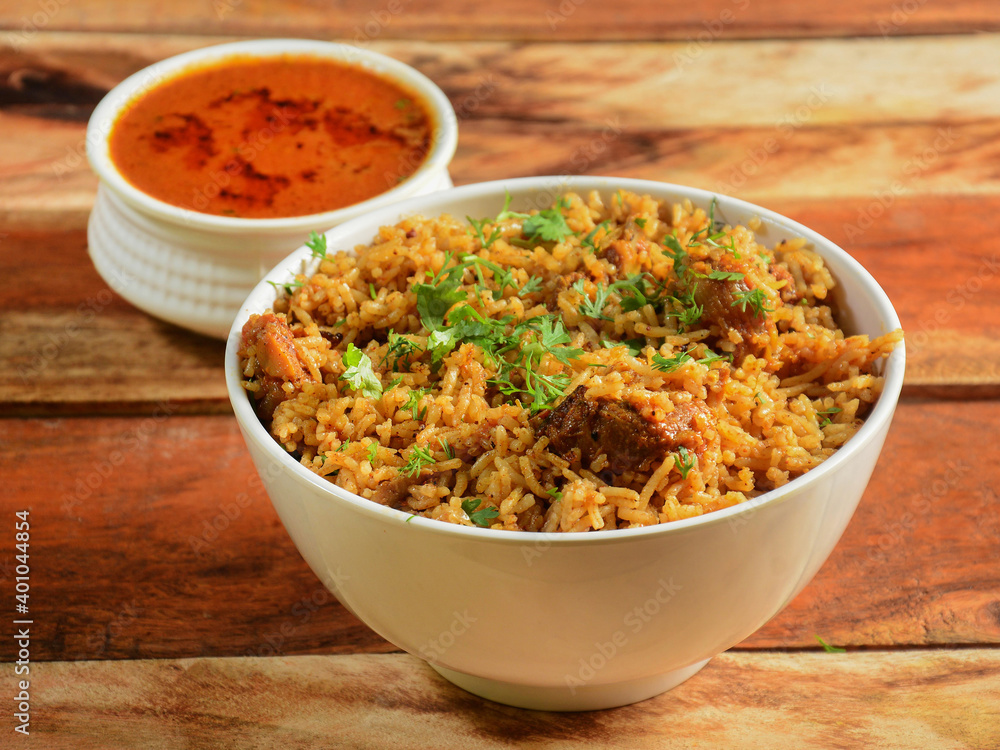 Mutton pulao cooked with masala spices, served over a rustic wooden background, selective focus Mutton pulao cooked with masala spices, served over a rustic wooden background, selective focus