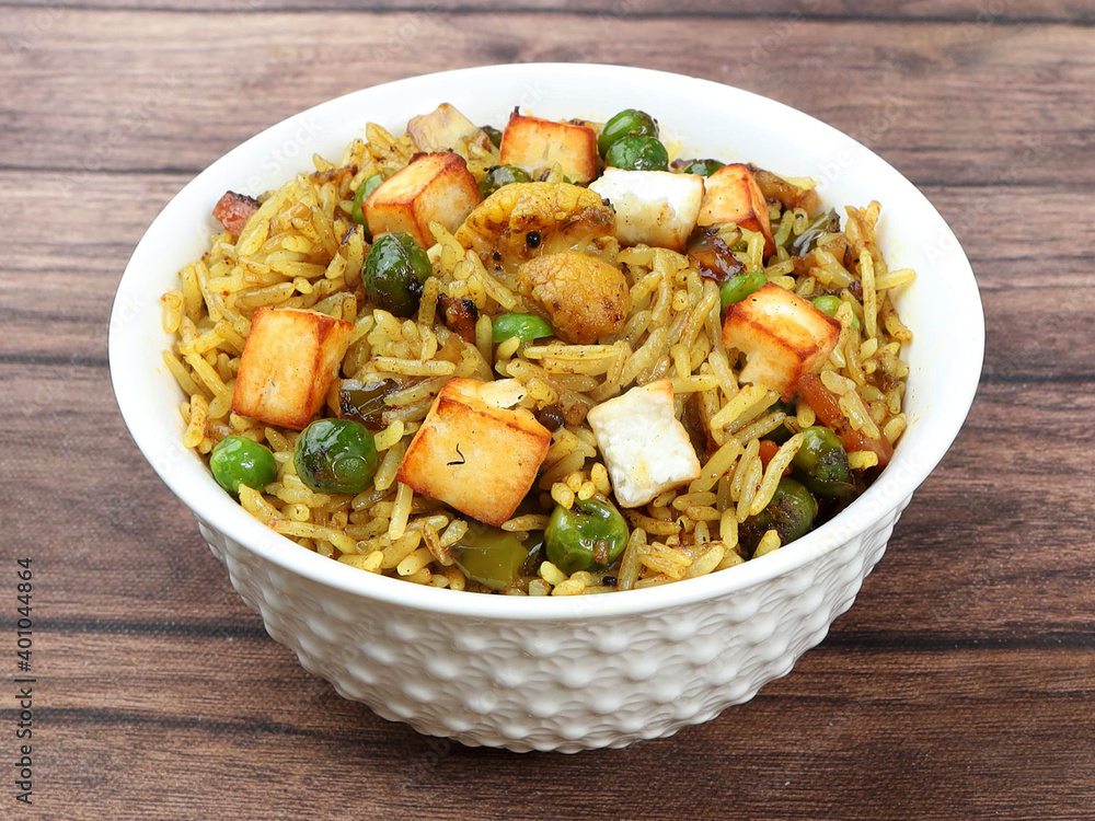 Paneer Pulao cooked with masala spices, served over a rustic wooden background, selective focus Paneer Pulao cooked with masala spices, served over a rustic wooden background, selective focus