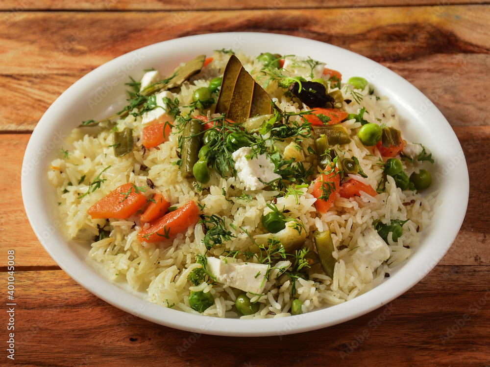 Veg pulao cooked with masala spices, served over a rustic wooden background, selective focus Veg pulao cooked with masala spices, served over a rustic wooden background, selective focus