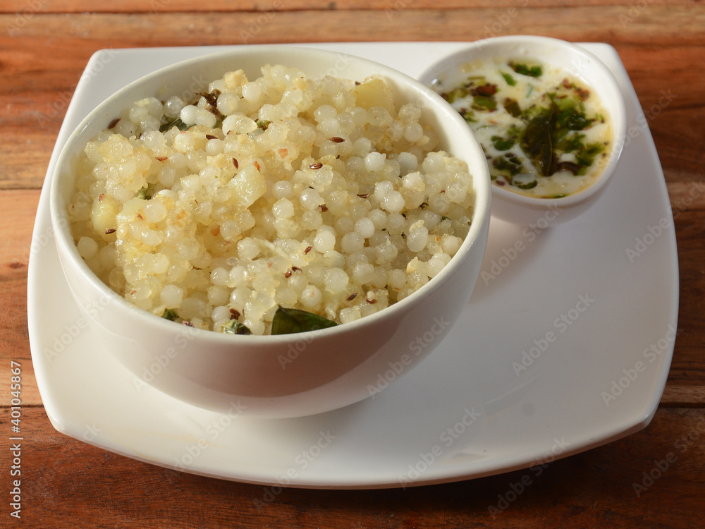 Sabudana khichdi / Khichadi is an Indian Fasting Food Recipe consume during navratri, ekadashi or ganesh chaturthi, dish isolated over a rustic wooden background, selective focus Sabudana khichdi / Khichadi is an Indian Fasting Food Recipe consume during navratri, ekadashi or ganesh chaturthi, dish isolated over a rustic wooden background, selective focus