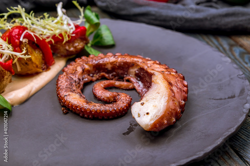 grilled octopus on black plate