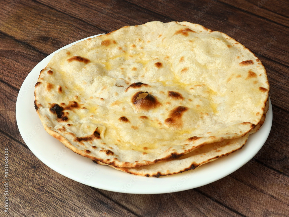 Butter roti, isolated over a rustic wooden background, selective focus Butter roti, isolated over a rustic wooden background, selective focus