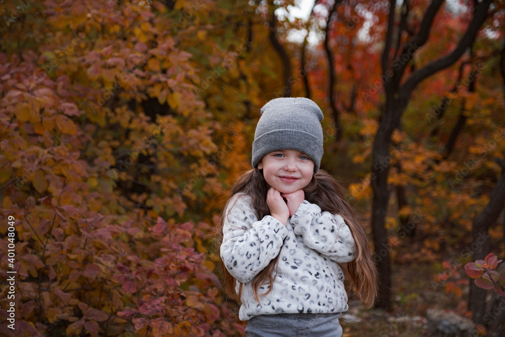 Cute kid girl 4-5 year old wearing sweater and jacket in park. Looking at camera. Autumn season. Childhood. Cute kid girl 4-5 year old wearing sweater and jacket in park. Looking at camera. Autumn season. Childhood.