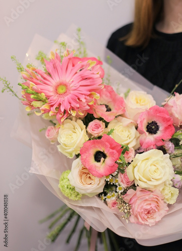 Flower shop. Beautiful bouquet of mixed flowers in bright pink color in woman s hands. Work of the florist at a flower shop.  Fresh cut flower.