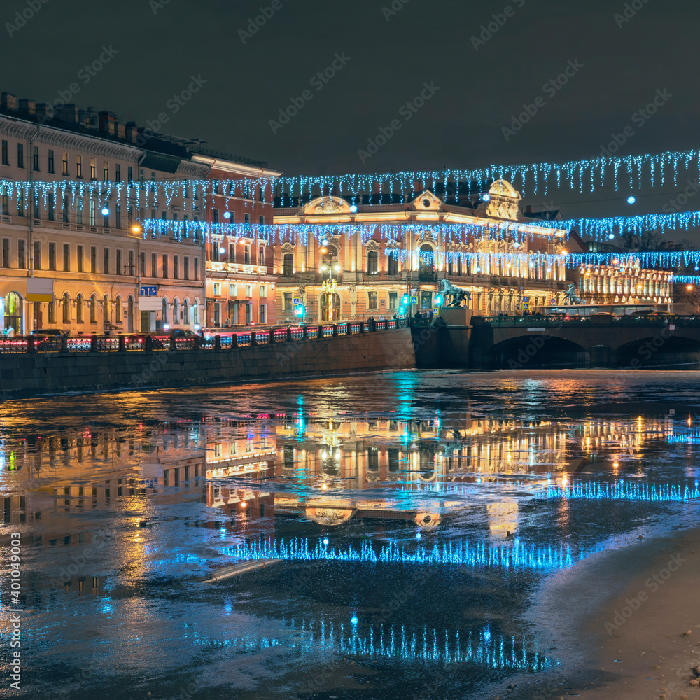 beautiful festive illumination along the embankment and the bridge, reflected in the water of the Fontanka River. St. Petersburg. Russia