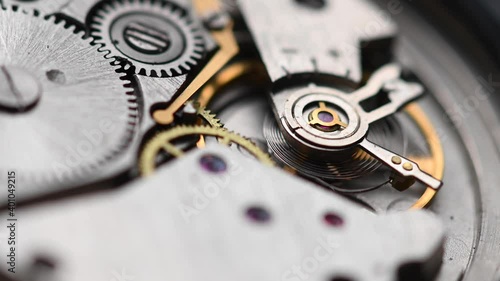 Internal working mechanism of the wristwatch with a rapidly rotating pendulum and gears. 4k clock close up with shallow depth of field