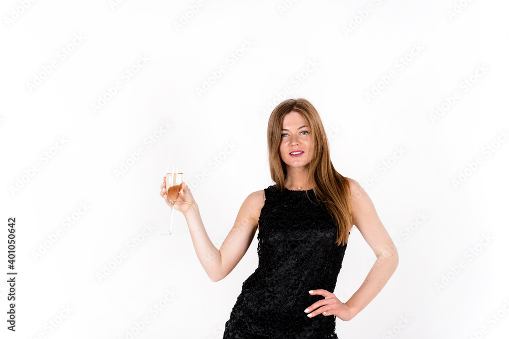 Young celebrating woman in black dress. Beautiful young woman isolated over white studio background holding champagne glass Young celebrating woman in black dress. Beautiful young woman isolated over white studio background holding champagne glass
