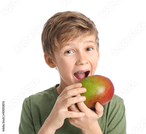 Cute little boy eating fresh tasty mango on white background