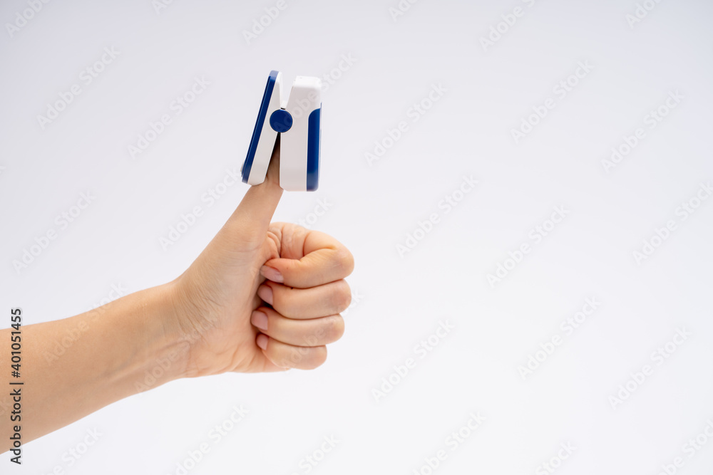 Finger pulse oximeter. On white background. The device is put on the thumb up. Health diagnostics Finger pulse oximeter. On white background. The device is put on the thumb up. Health diagnostics