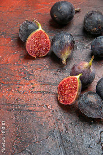 Vertical view of full fresh black mission figs split ones on colorful background photo