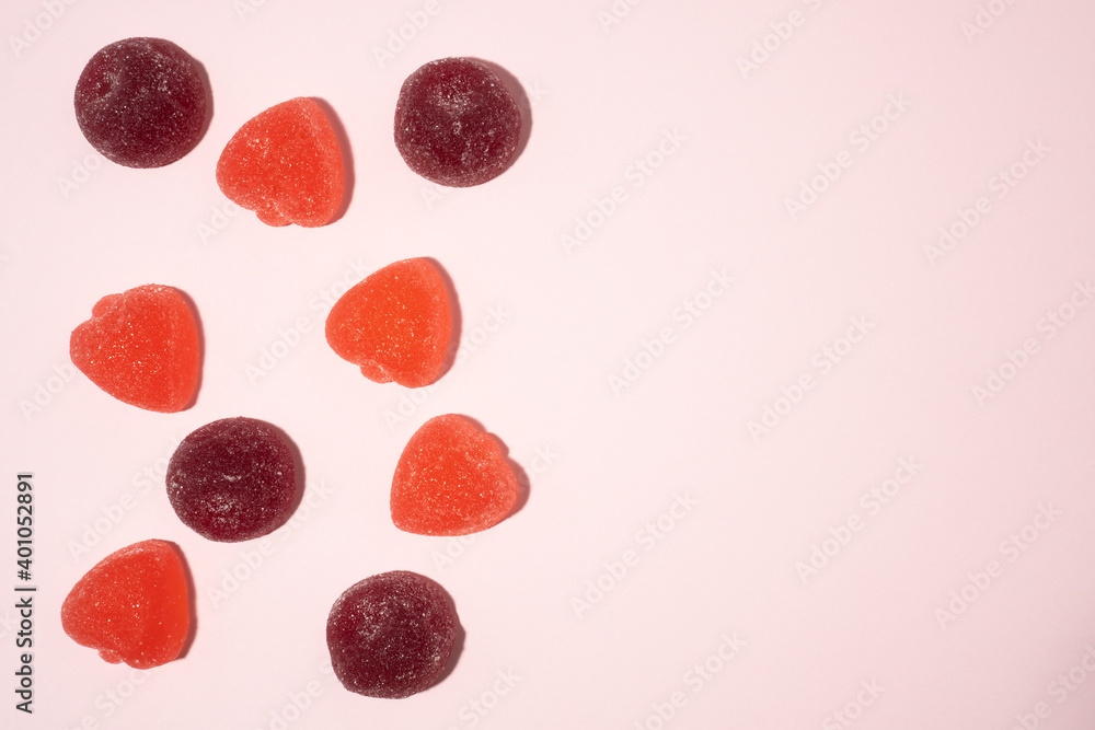 Delicious berries flavored marmalade or gummy candies with natural juice on soft pink background with copy space. Delicious berries flavored marmalade or gummy candies with natural juice on soft pink background with copy space.