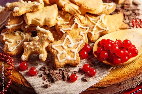 Christmas gingerbread cookies, chocolate and frozen berries, on a wooden stand, red background, large depth of field, selective focus. Christmas and New Year concept.