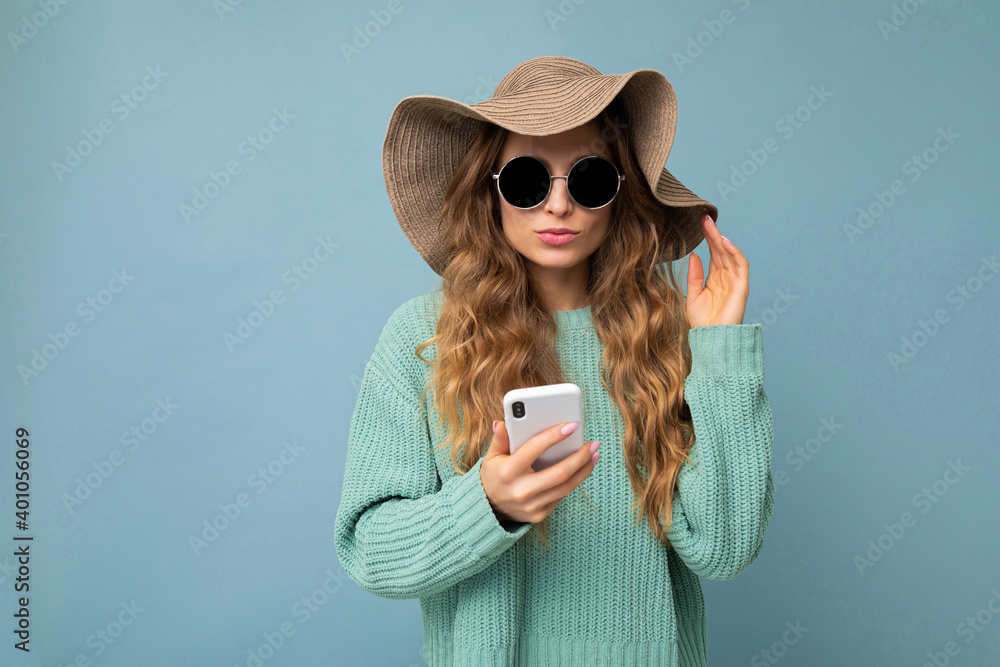 Beautiful young blonde woman wearing blue sweater hat and sunglasses standing is Ivan Traimak Foto Poster Wandbilder bei EuroPosters
