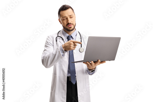 Male doctor holding a laptop computer and pointing at the screen