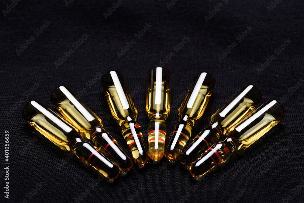 brown glass ampoules with liquid medicine on black brown glass ampoules with liquid medicine on black